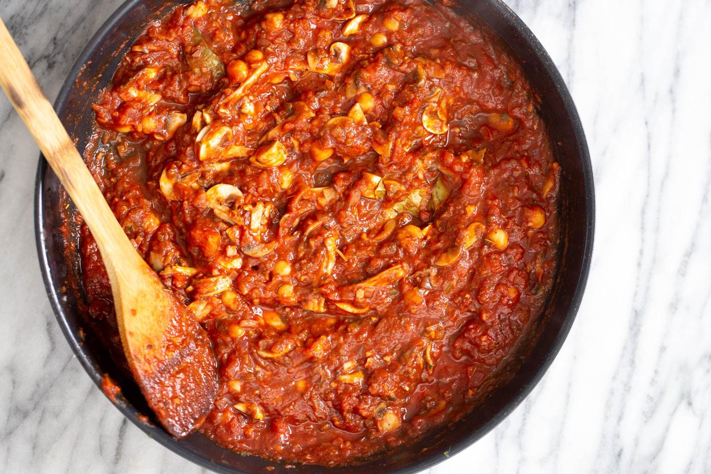 sauce for vegan stuffed bell peppers in a black skillet