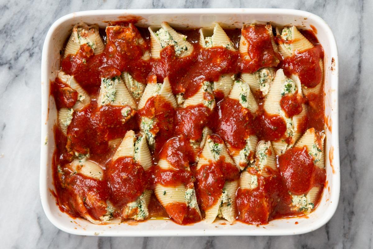 stuffed shells placed in a casserole dish with marinara sauce