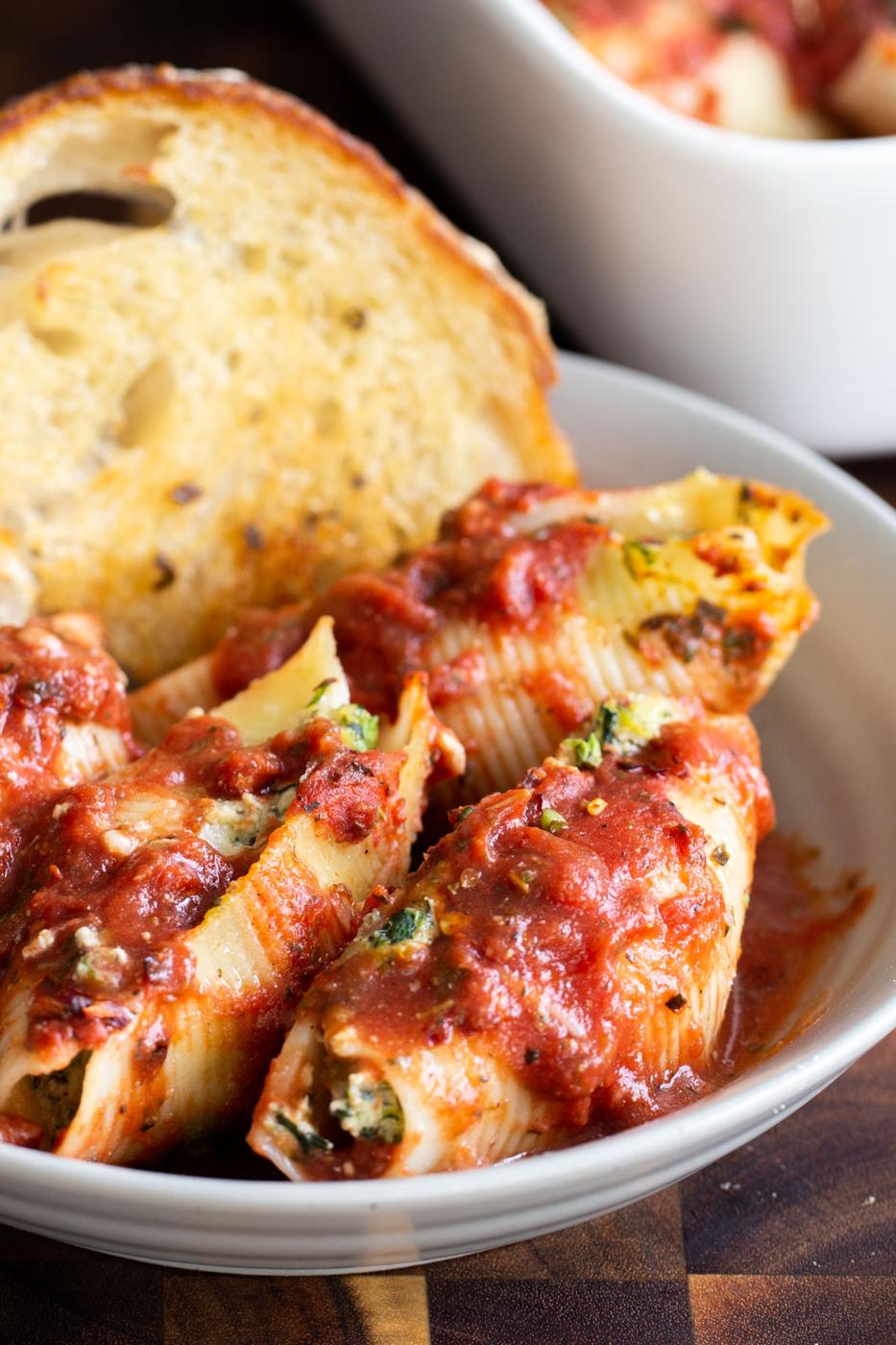 vegan stuffed shells served with a slice of bread