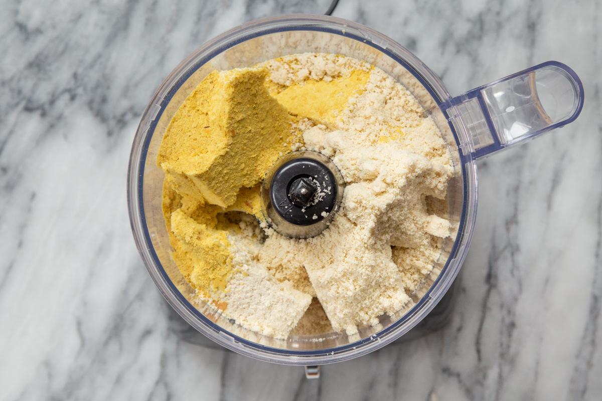nutritional yeast, tofu and vegan parmesan cheese in a food processor