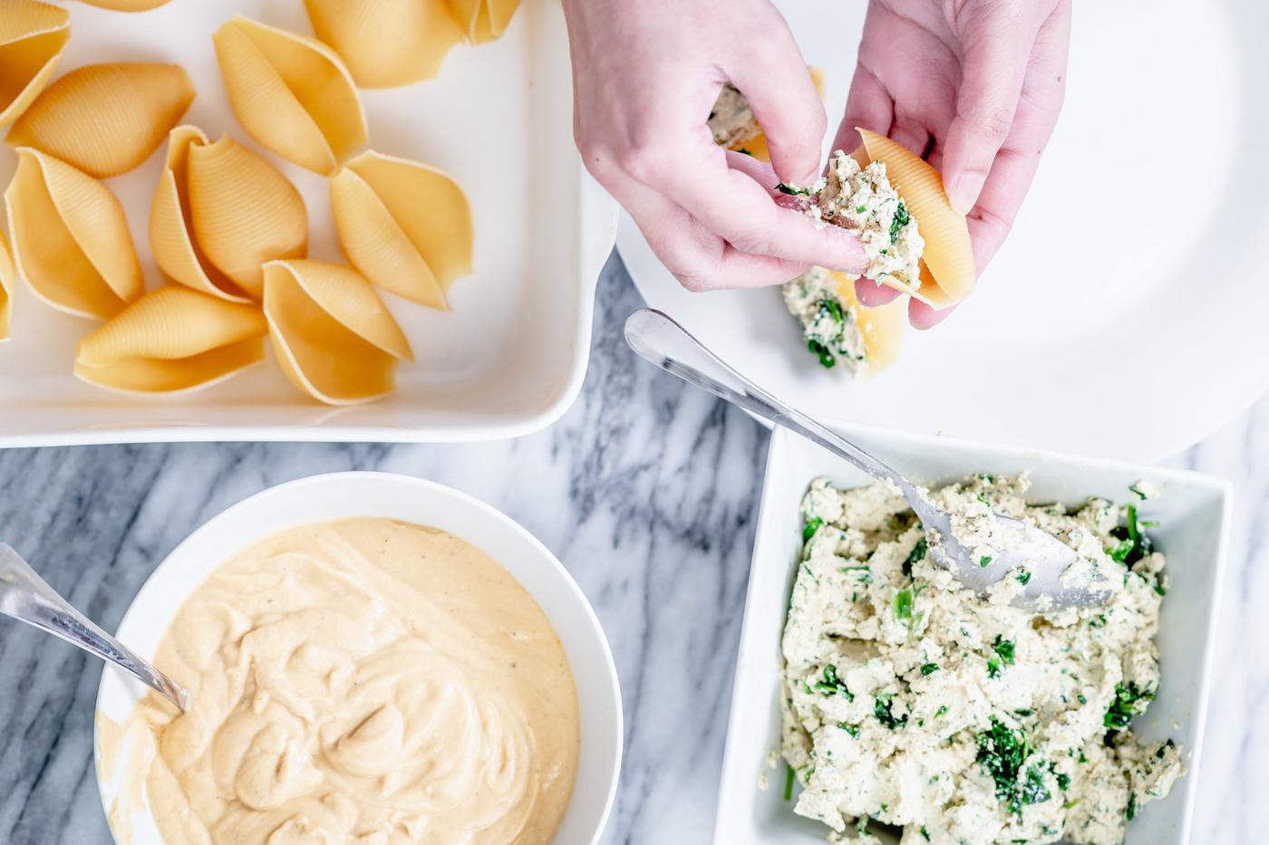 shell pasta being stuffed with tofu ricotta spinach mix