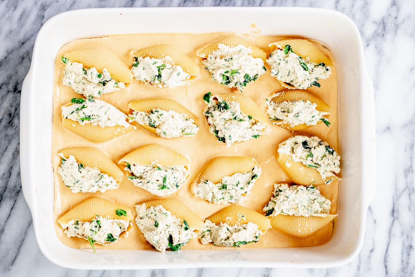 overhead shot of vegan tofu ricotta stuffed shells on butternut squash alfredo