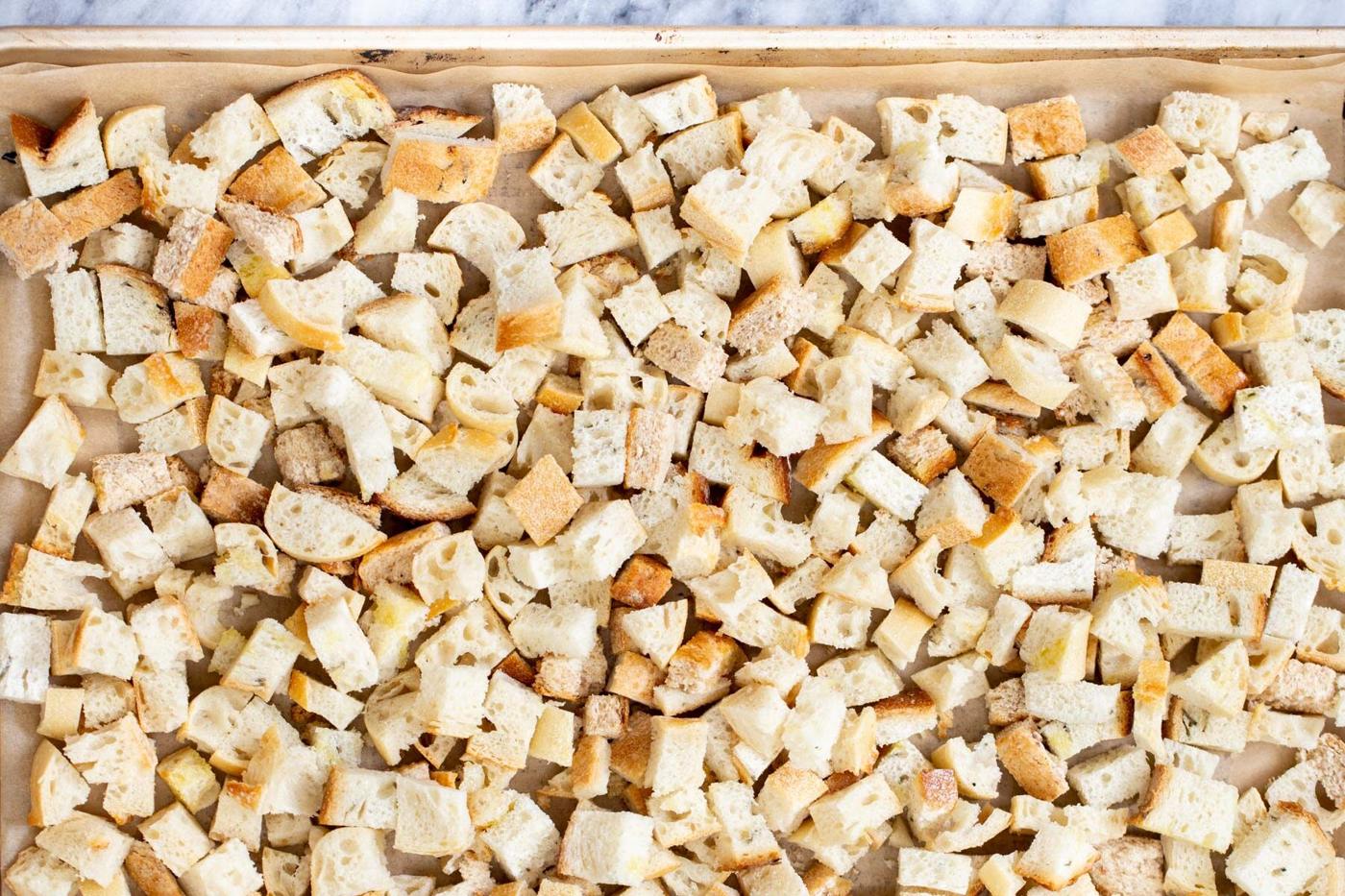 vegan bread cubes on a lined baking sheet