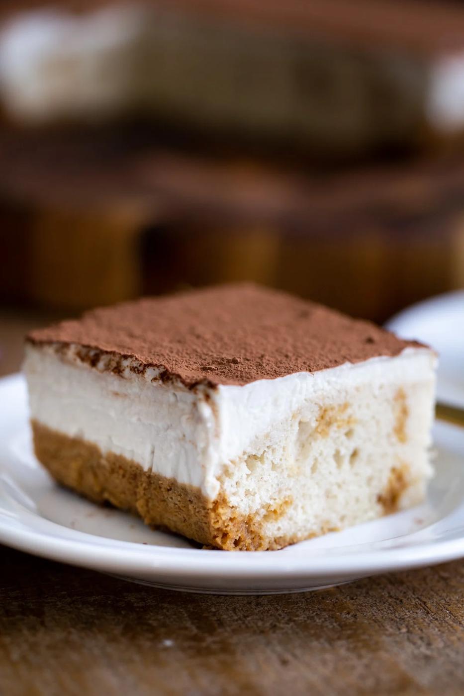 a slice of vegan tiramisu sheet cake on a white cake platter