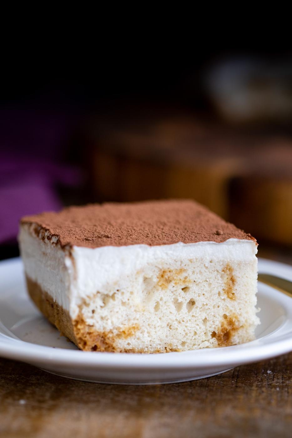 a piece of vegan tiramisu sheet cake dusted with cocoa powder
