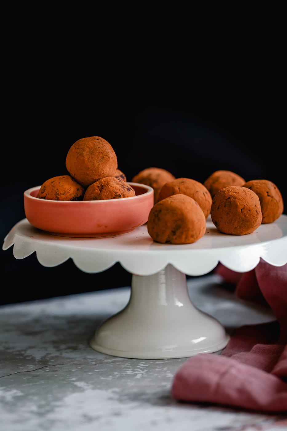 a cake stand with cocoa-dusted vegan Tiramisu truffles made with vegan cream cheese
