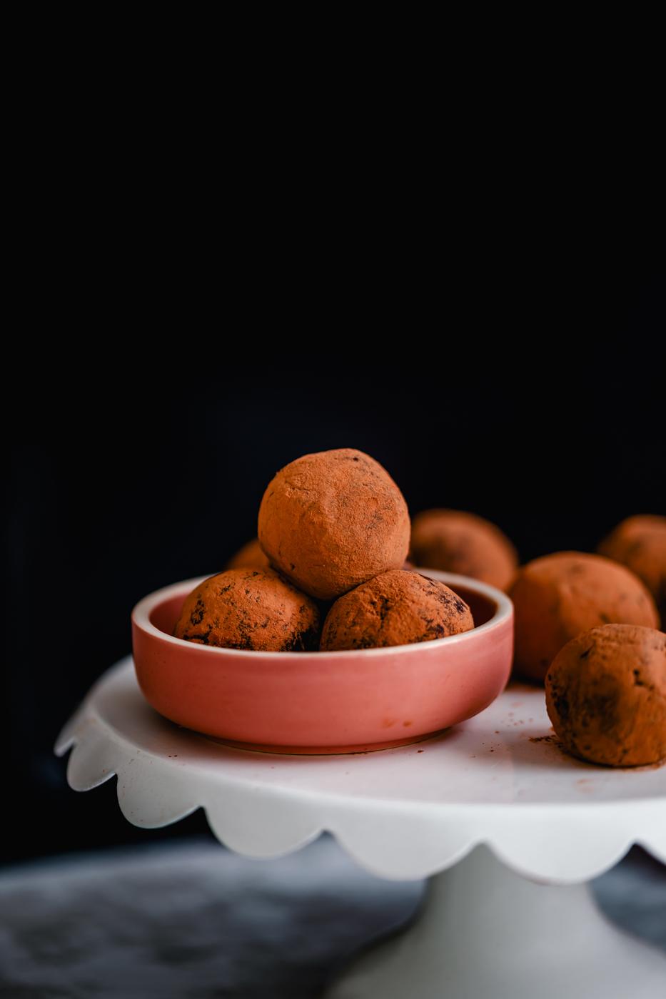 vegan homemade tiramisu truffles in a small pink bowl placed on a cake stand