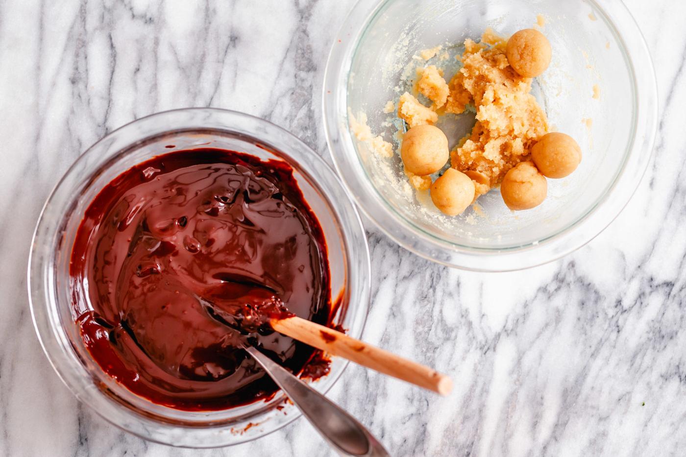 a bowl of melted chocolate glaze and a bowl with vegan almond truffle mixture