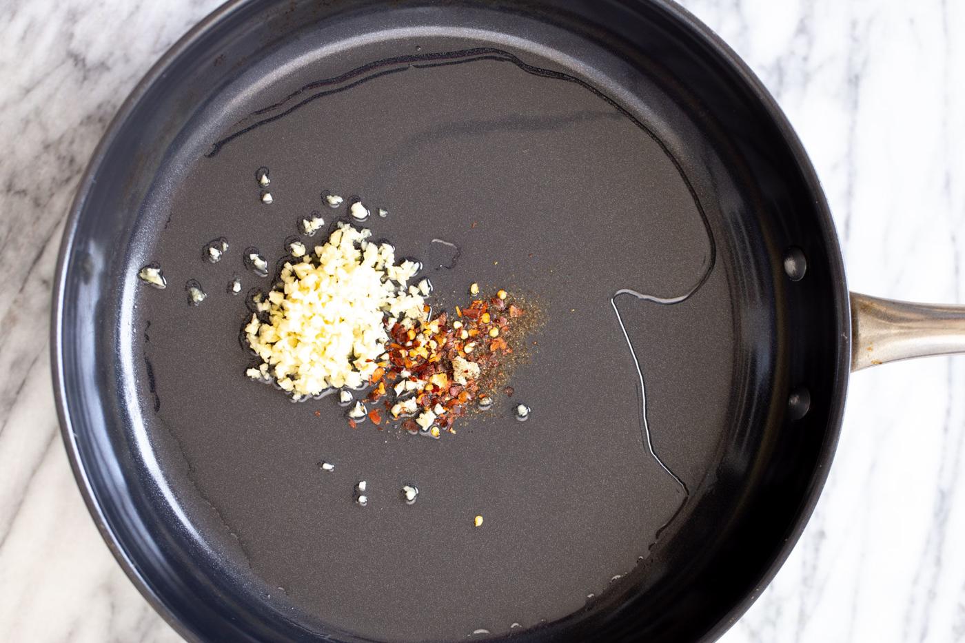 garlic and red pepper flaked being fried in oil to make vegan breakfast recipe