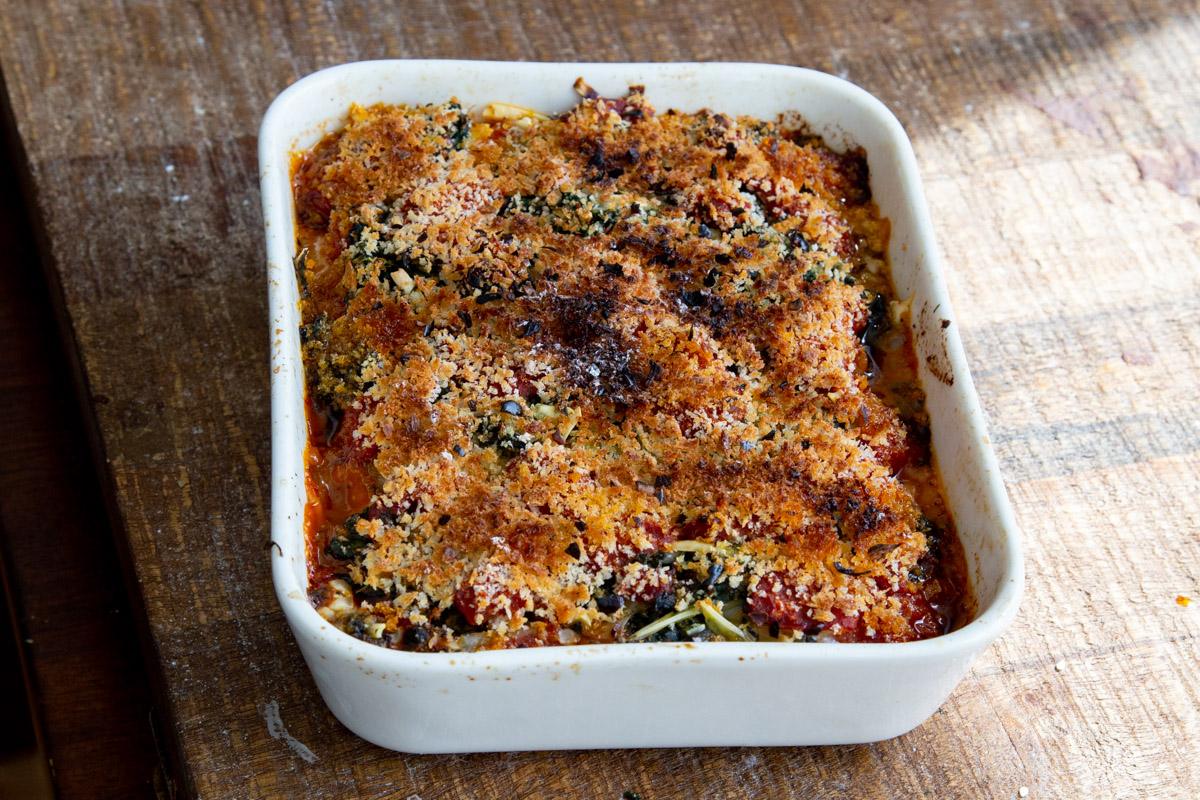 freshly baked tofu lasagna on a wooden board