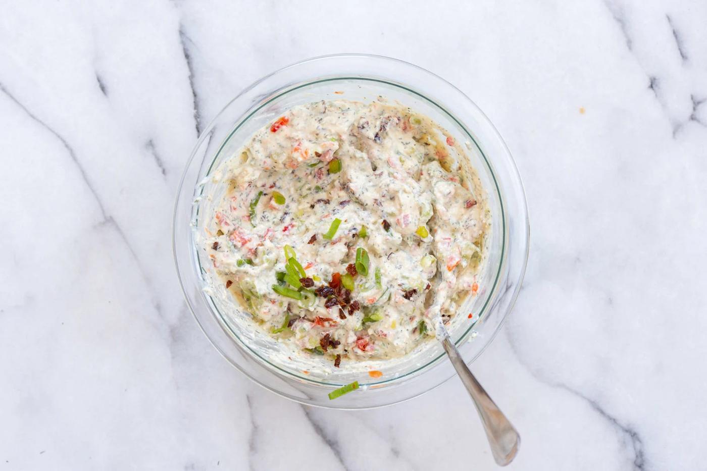 Dairy free cream cheese mixed with veggies in a bowl for our Vegan Tortilla Roll ups recipe
