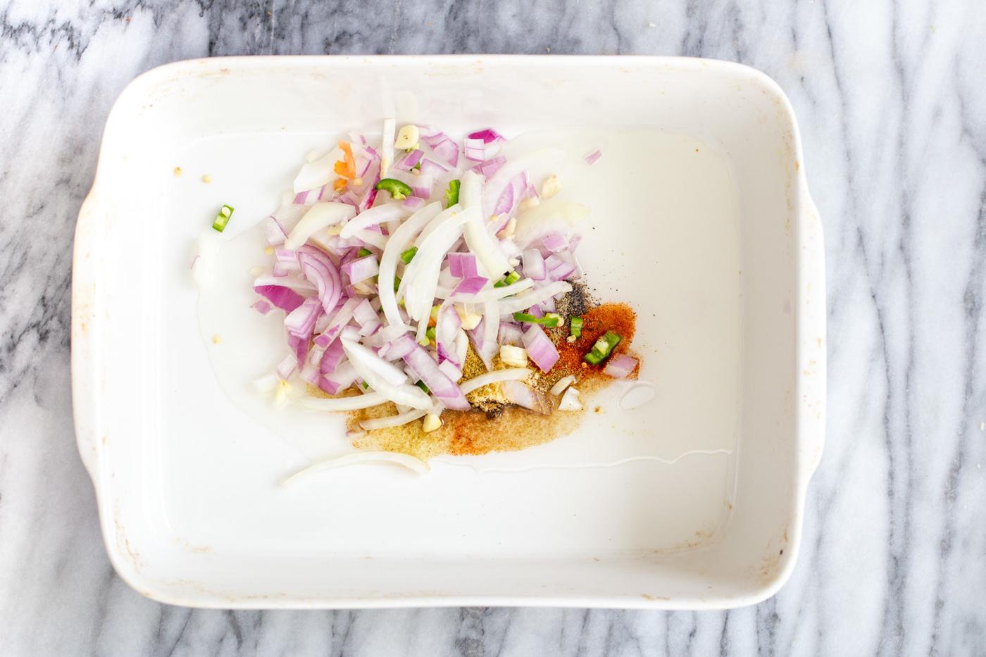 oil, spices onion, chili and garlic in a white casserole dish