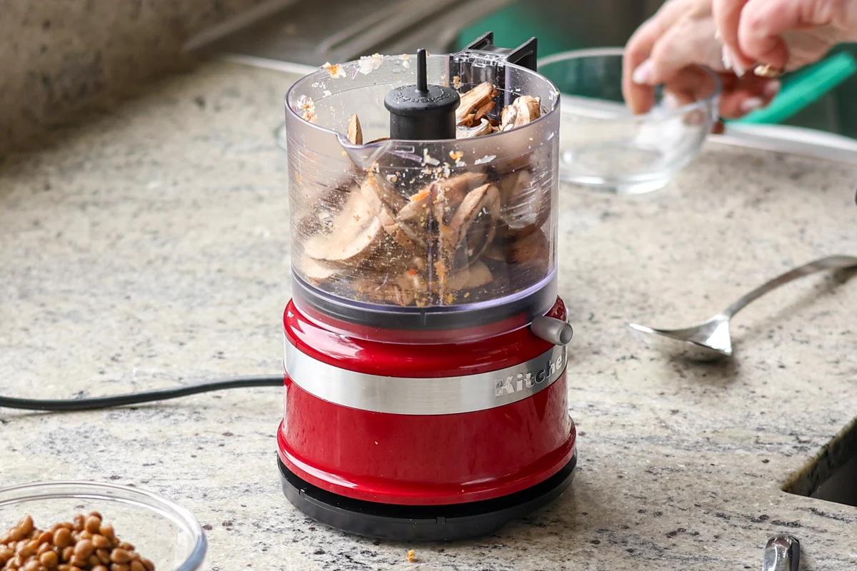 adding mushrooms to the food processor