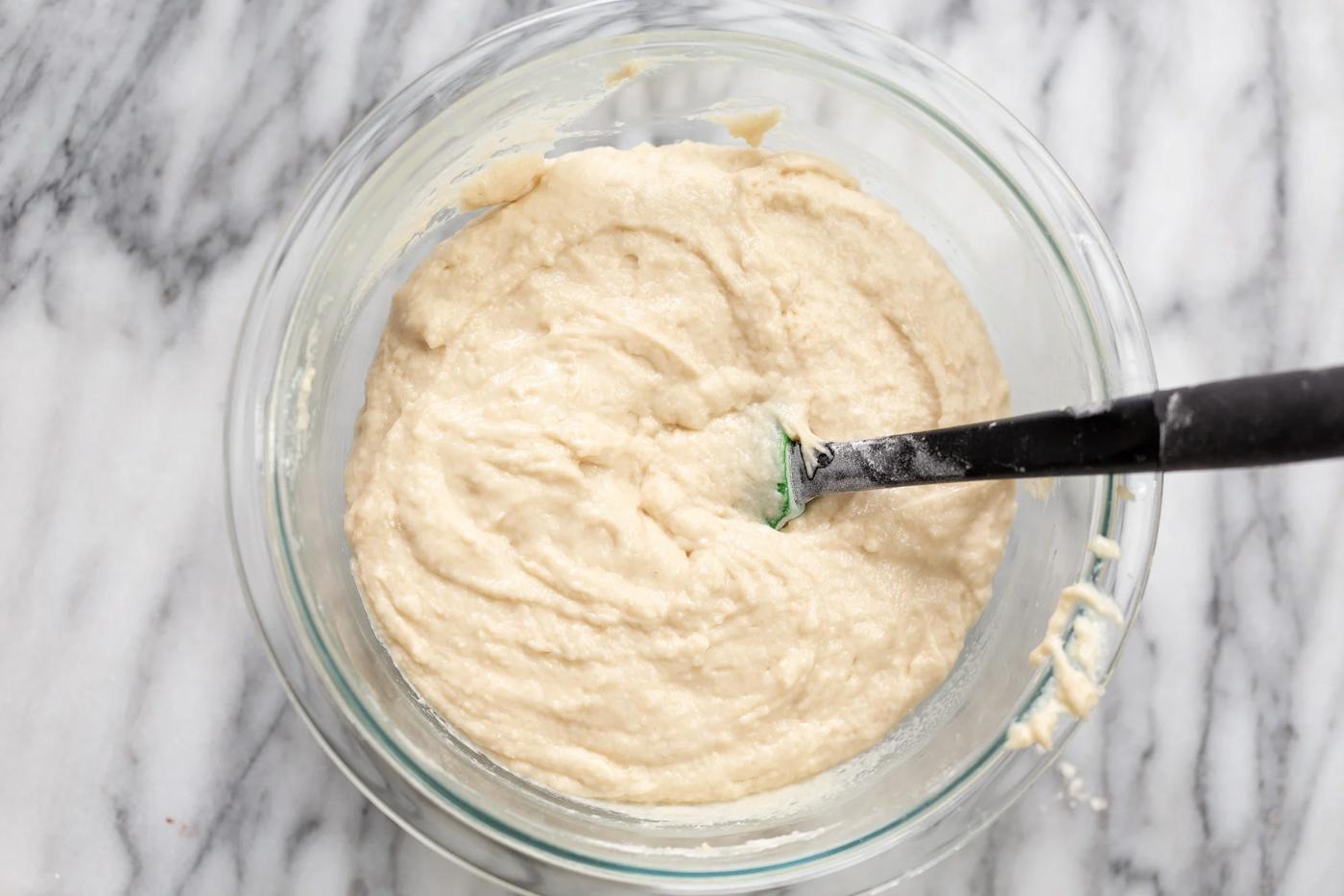 vegan white cake batter being mixed in a glass bowl