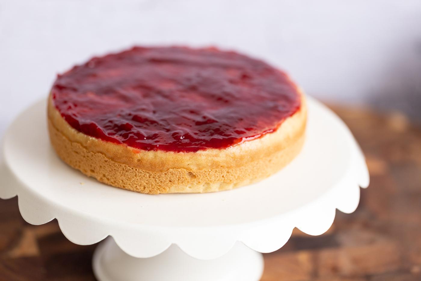 vegan sponge cake topped with raspberry jam