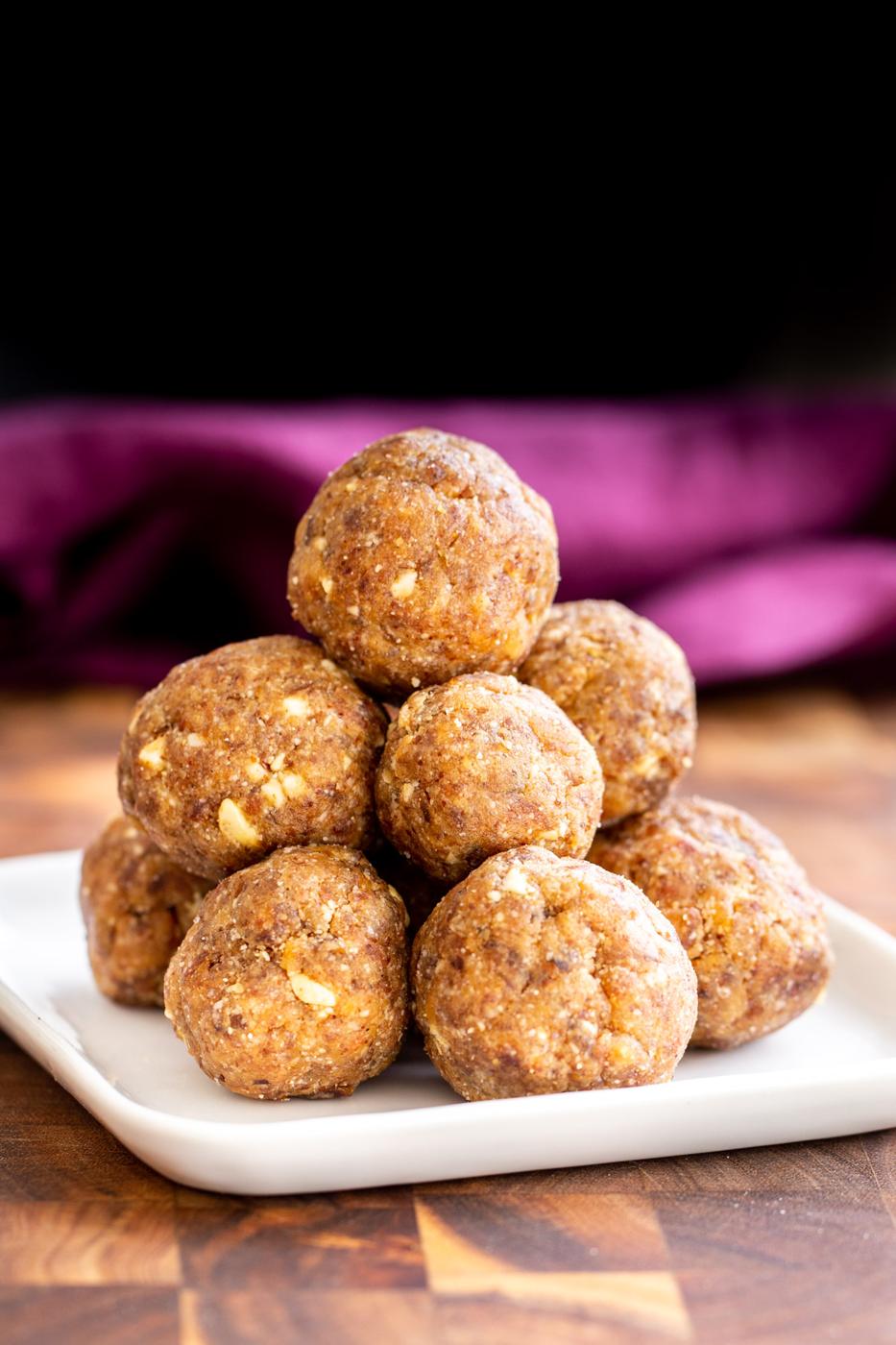 a plate with stacked vegan ladoos sweetened with dates