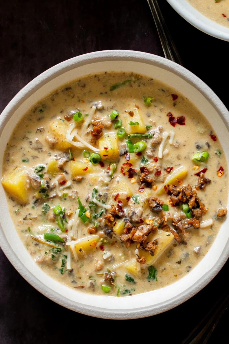 overhead shot of a bowl of creamy vegan zuppa toscana topped with chopped chives