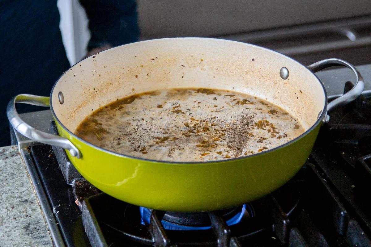 sausage, vegetables and cashew cream simmering in a green saucepan