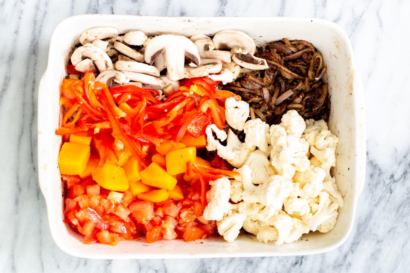 healthy vegetables assembled in a casserole dish to make balti vegetables