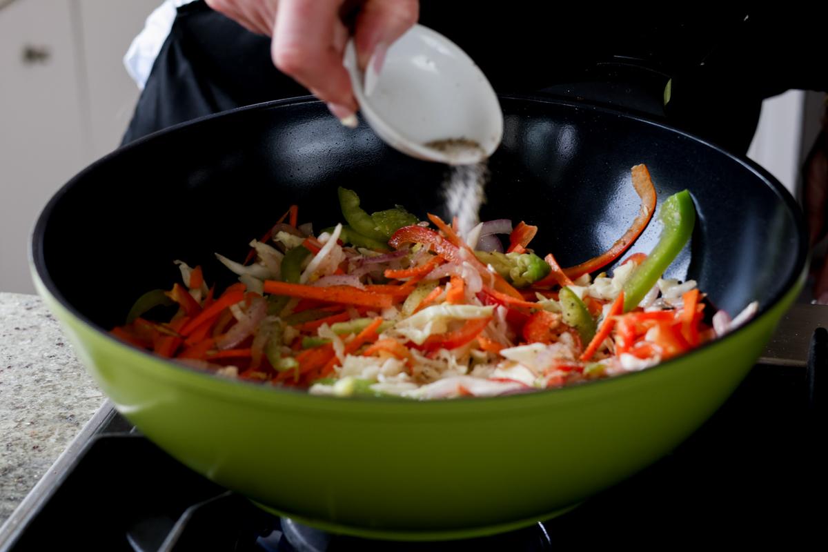 adding salt and pepper to the veggies