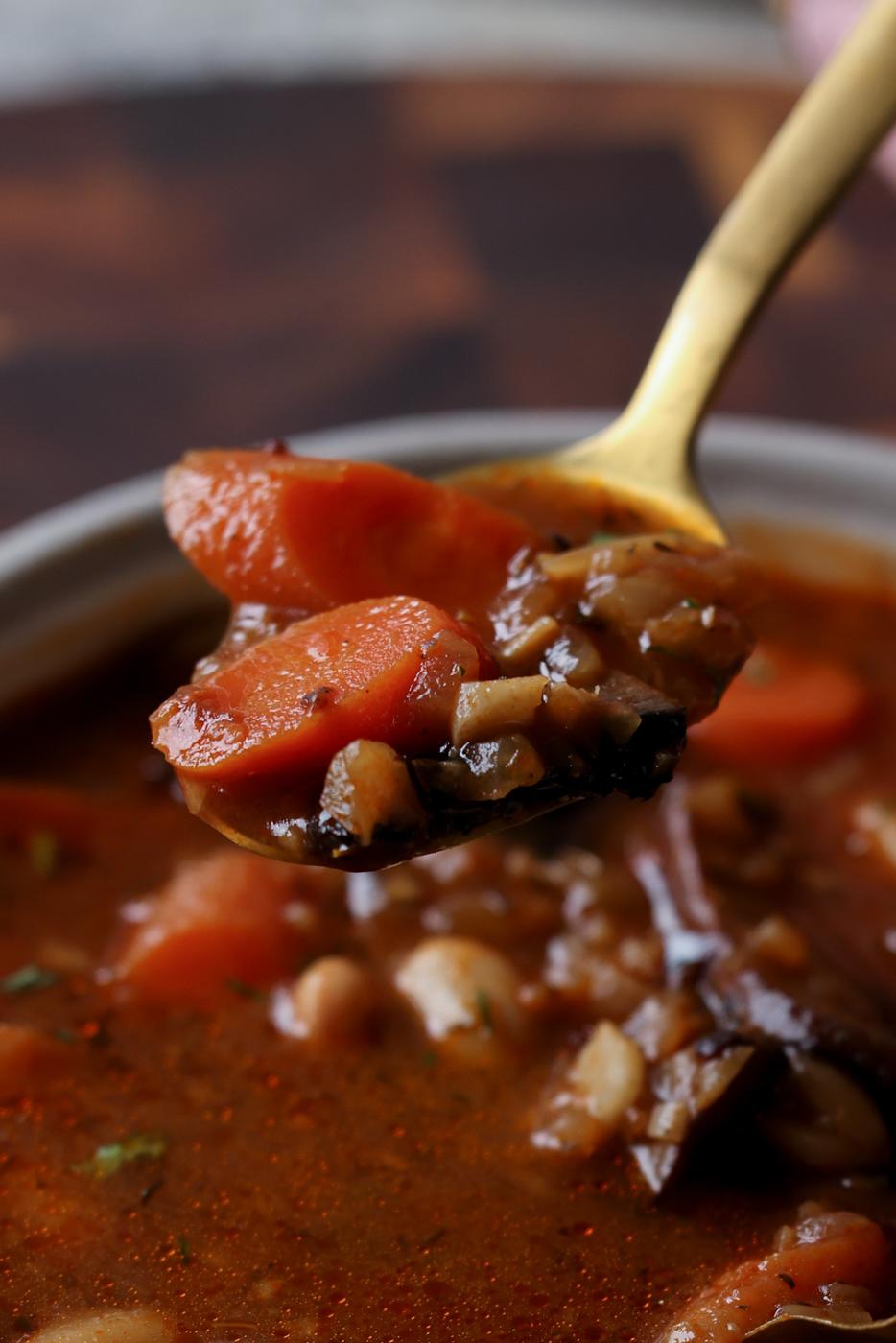 spoon taking a bite of veggie bean stew