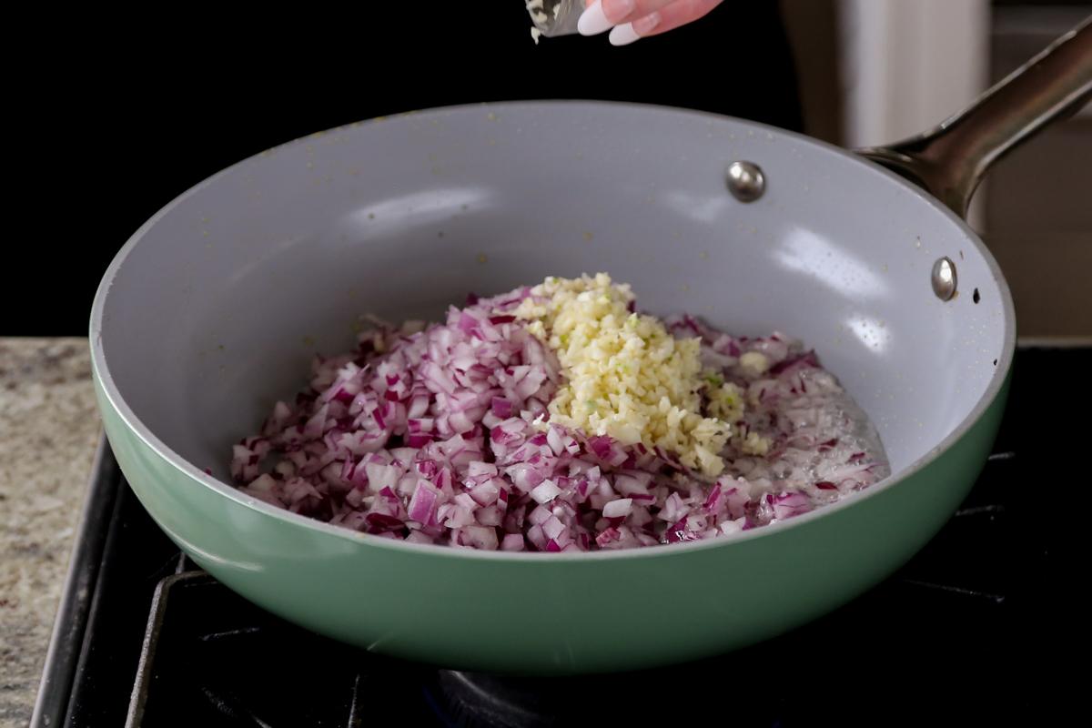 adding onion and garlic to the pan