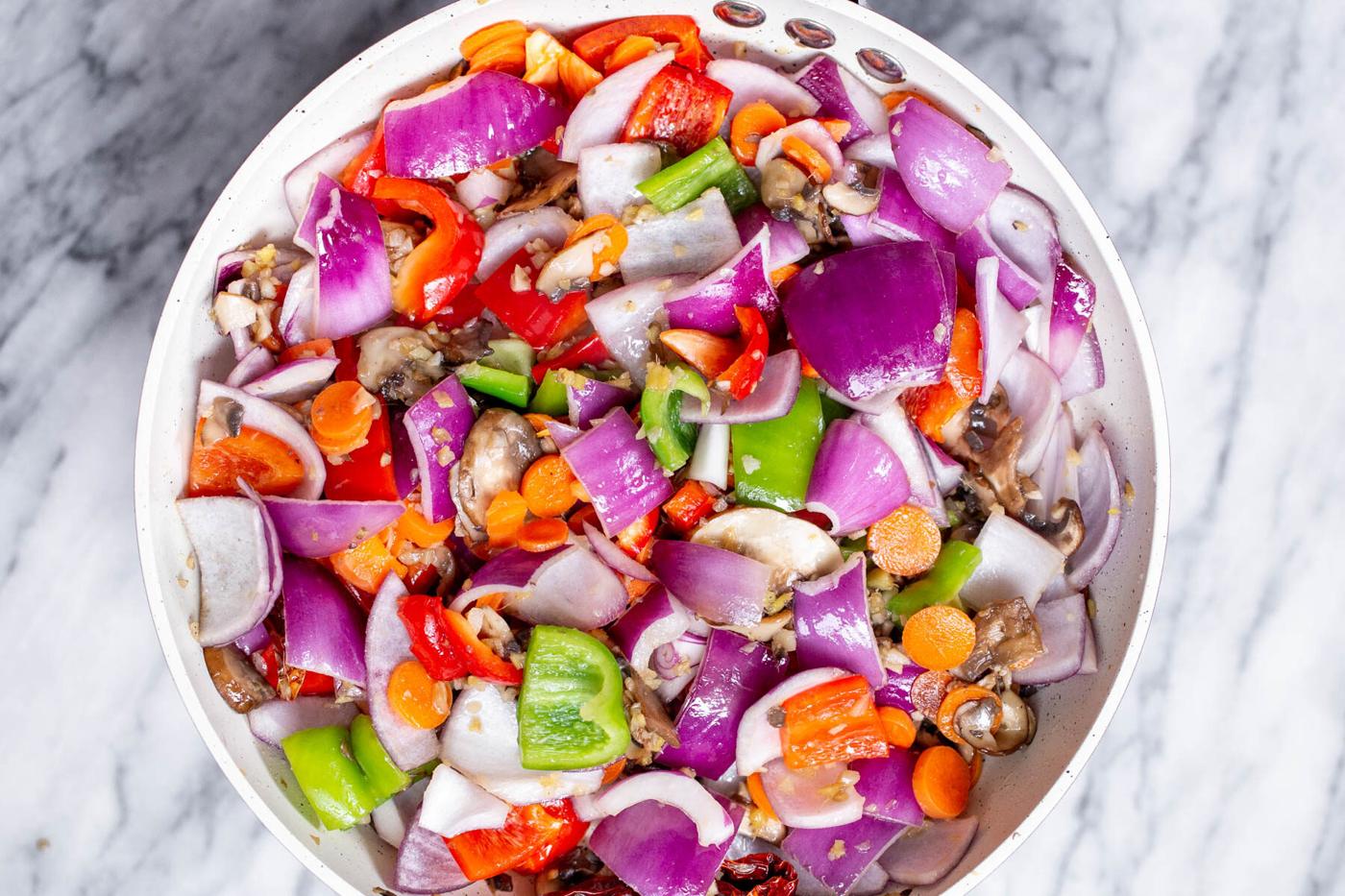 chopped veggies frying in a pan