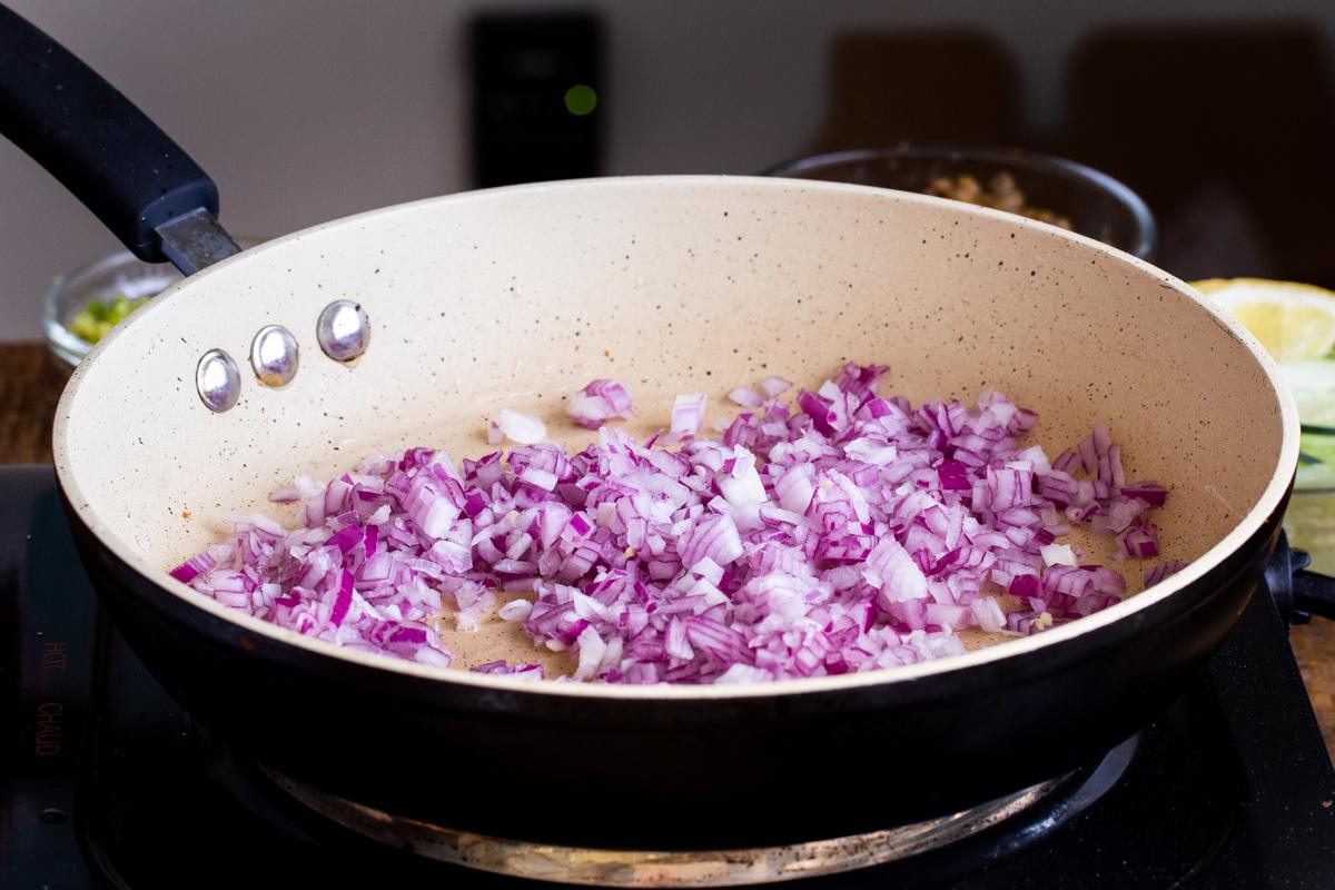 minced red onions in a sauteeing pan