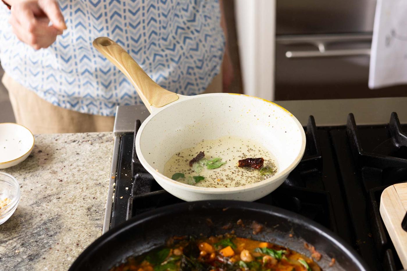 adding chilies and curry leaves to the pan
