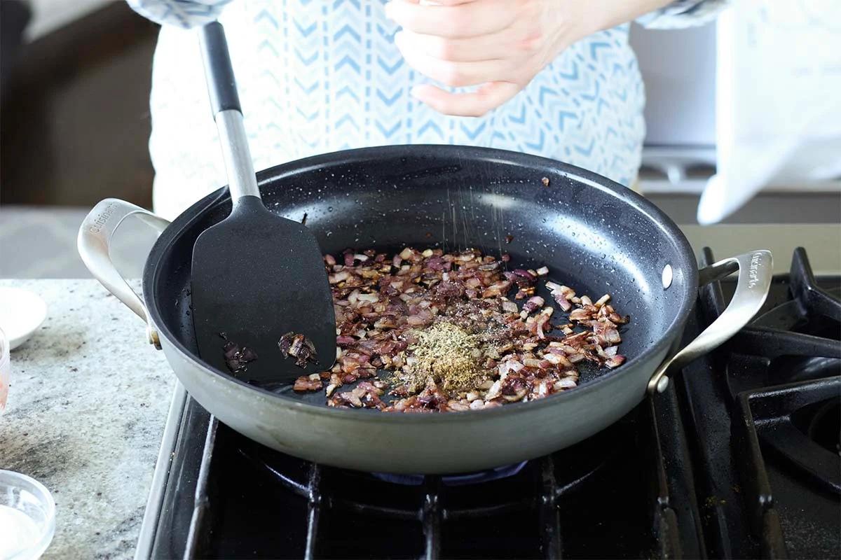 adding more herbs and spices to the pan