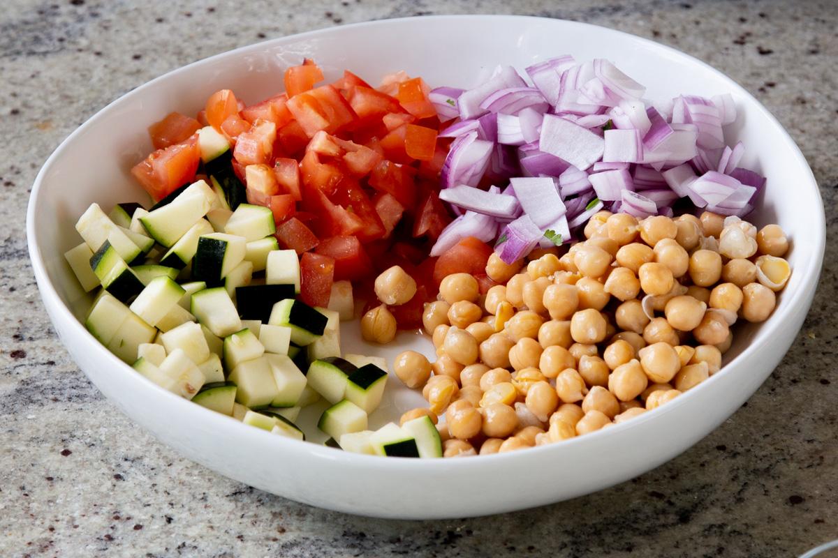 adding red onion to the salad bowl