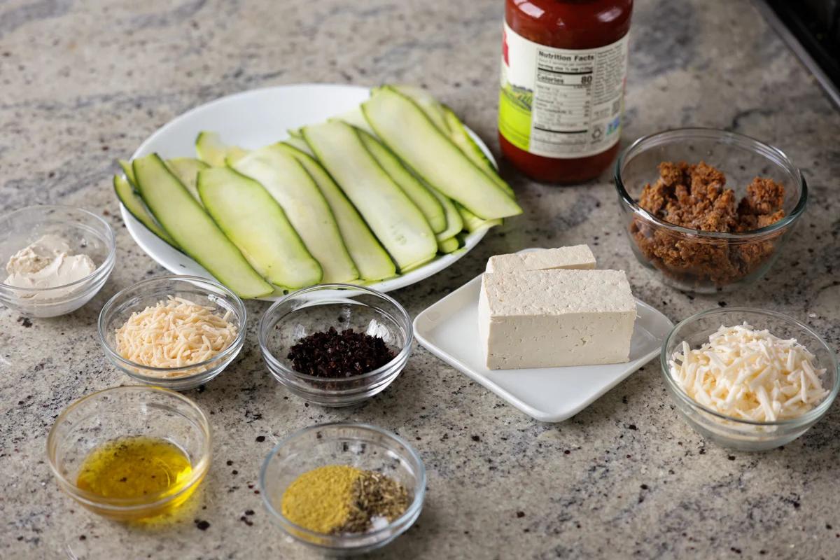 zucchini roll ingredients in bowls on a kitchen counter