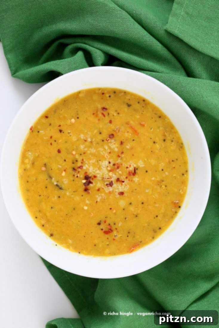 Close-up of Sri Lankan Red Lentil Curry in a rustic bowl, garnished with fresh herbs. A delicious and easy vegan, gluten-free, soy-free, no-garlic recipe. | VeganRicha.com #vegan #easy #glutenfree #soyfree #lentils #dal #recipe