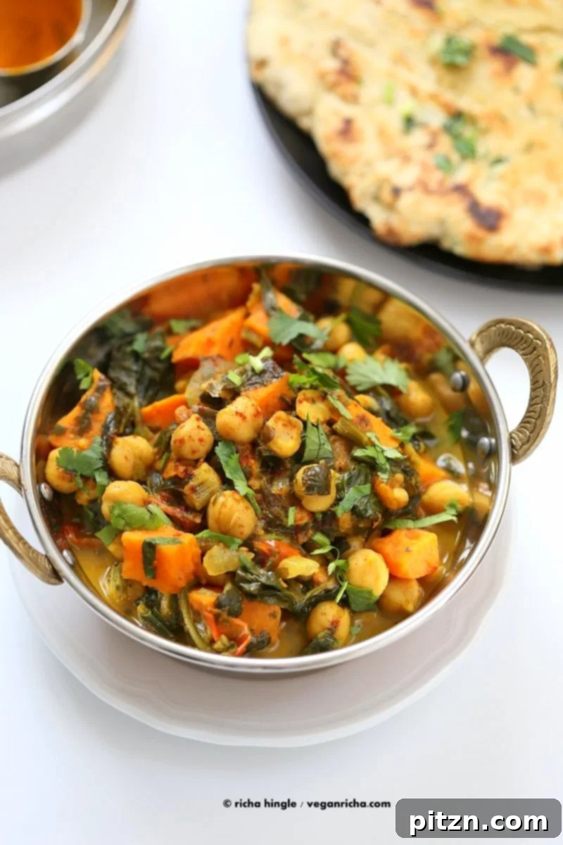 Hearty One-Pot Chickpea Sweet Potato Spinach Curry 6 A beautifully plated bowl of One-Pot Chickpea, Sweet Potato, and Spinach Curry, garnished with fresh cilantro, ready to be served with a side of rice or flatbread. A healthy, vegan, gluten-free, and soy-free meal option.
