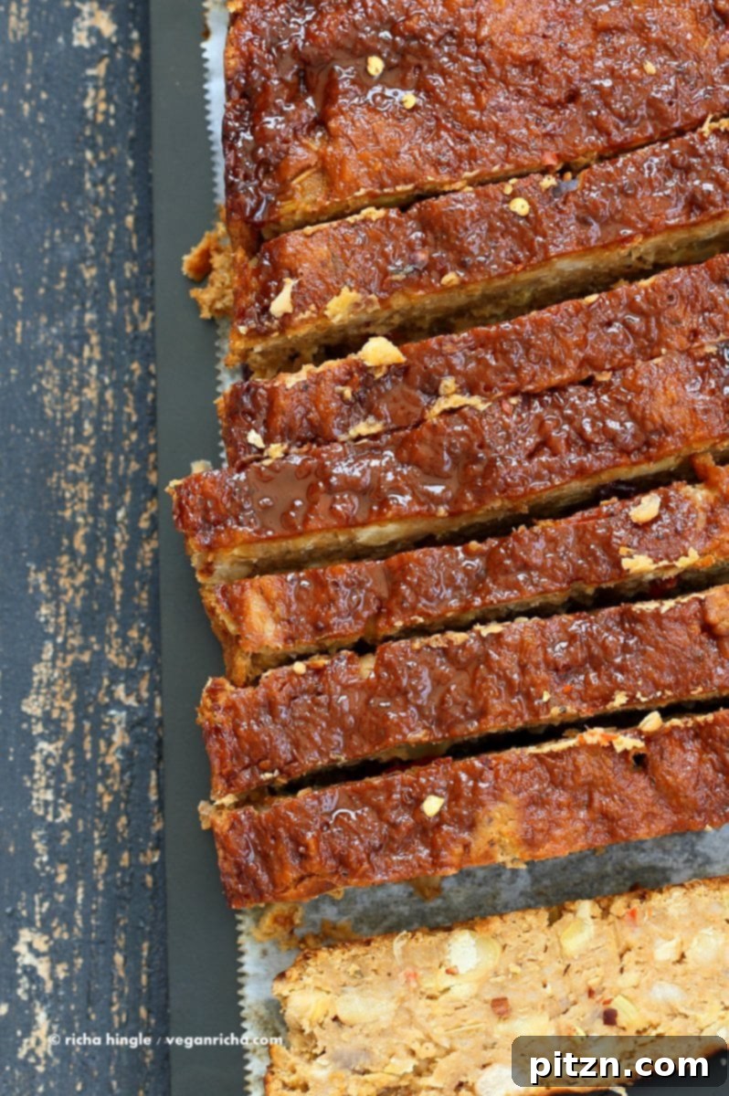 Delicious Plant-Based Chickpea Meatloaf 11 A generously portioned slice of Chickpea Veggie Loaf, showcasing its textured interior and inviting aroma, ready for a festive holiday table.