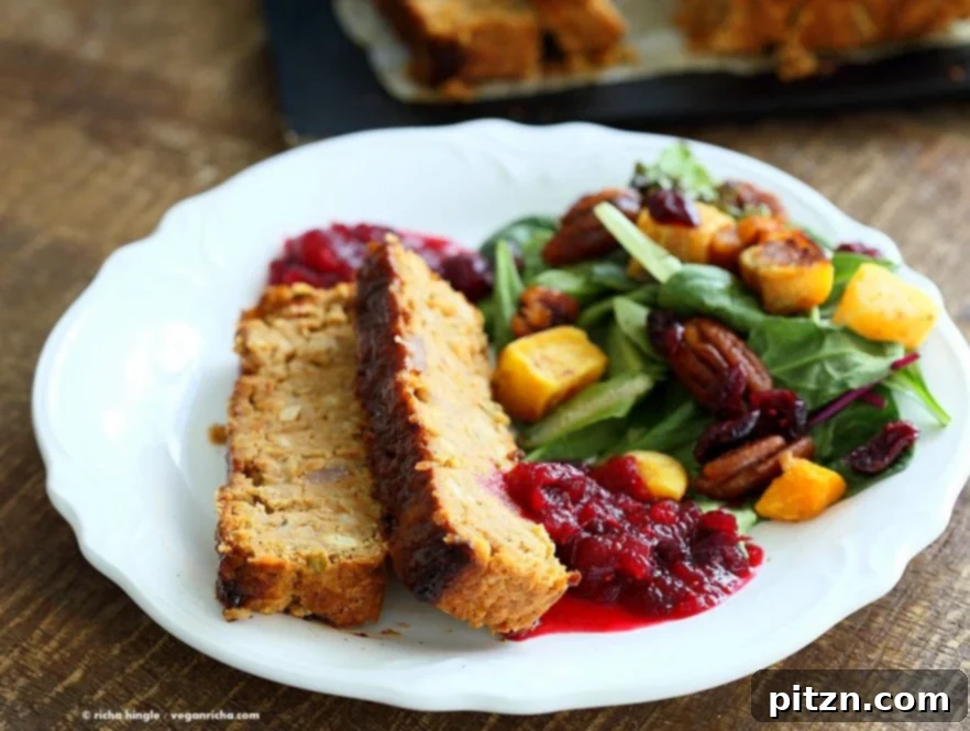 Delicious Plant-Based Chickpea Meatloaf 9 A close-up of a serving of Chickpea Veggie Loaf with sides like mashed potatoes and cranberry sauce, showcasing a festive holiday meal.