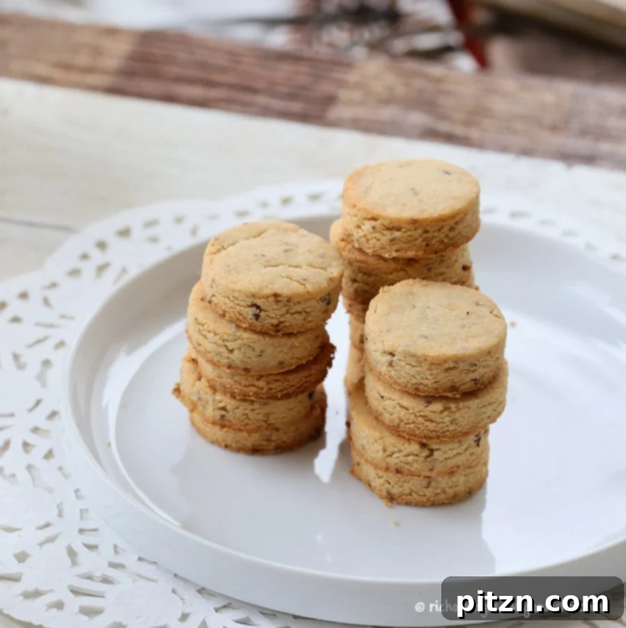 vegan sugar cookies stacked on a white cookie platter