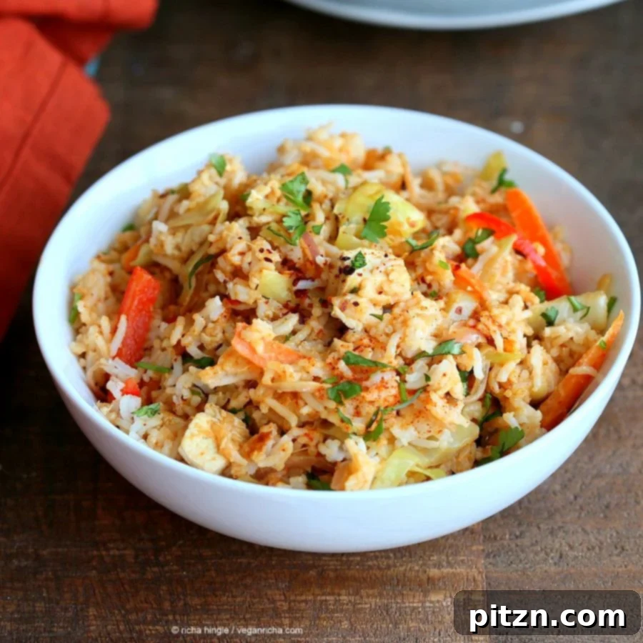 Savory Peanut Fried Rice 6 A vibrant bowl of Vegan Peanut Sauce Fried Rice, garnished with fresh herbs and a lime wedge, ready to be served.