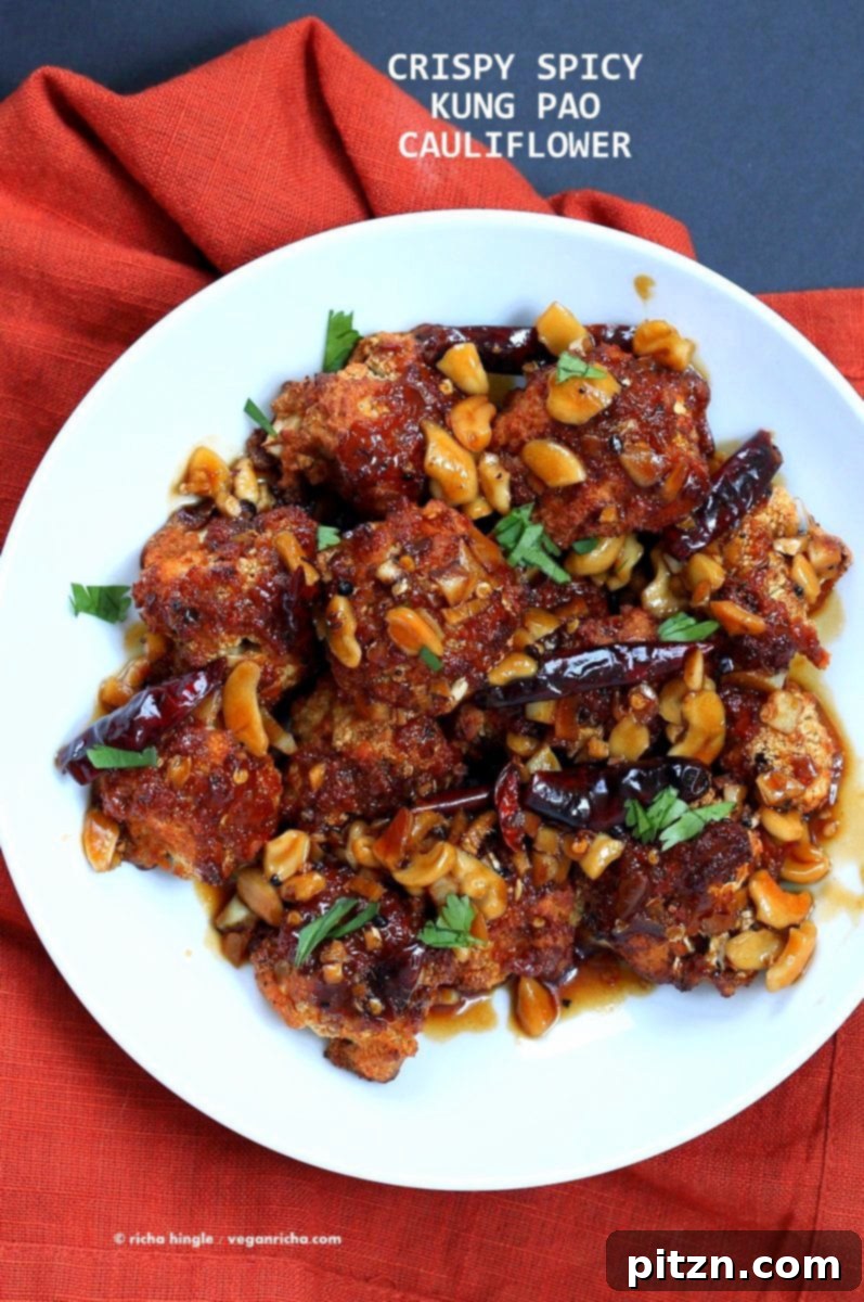 Spicy Crispy Kung Pao Cauliflower, an enticing vegan appetizer featuring battered and baked cauliflower florets covered in a flavorful Kung Pao sauce. Perfect for sharing or as a meal. | VeganRicha.com #vegan #appetizer #snack #cauliflower #kungpao #recipe