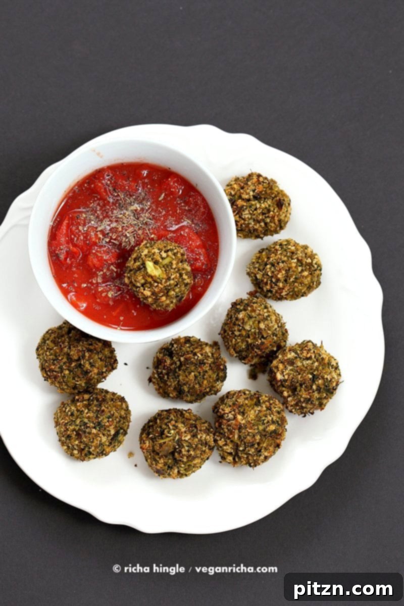 Baked Vegan Broccoli Balls, golden and crispy, served with marinara. These easy, gluten-free friendly veggie 'meatballs' are perfect with pasta or in a sub. #vegan #recipe #broccoli #healthy