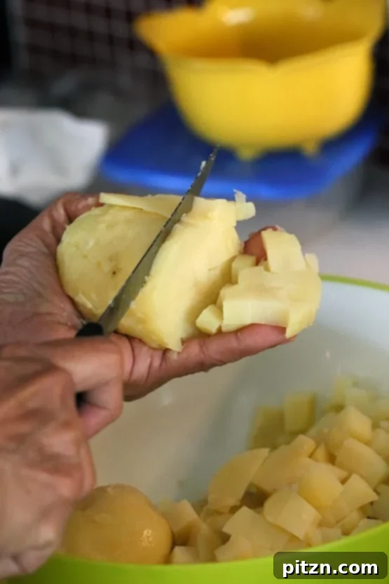 Boiled potatoes being chopped for Vegan Aloo curry