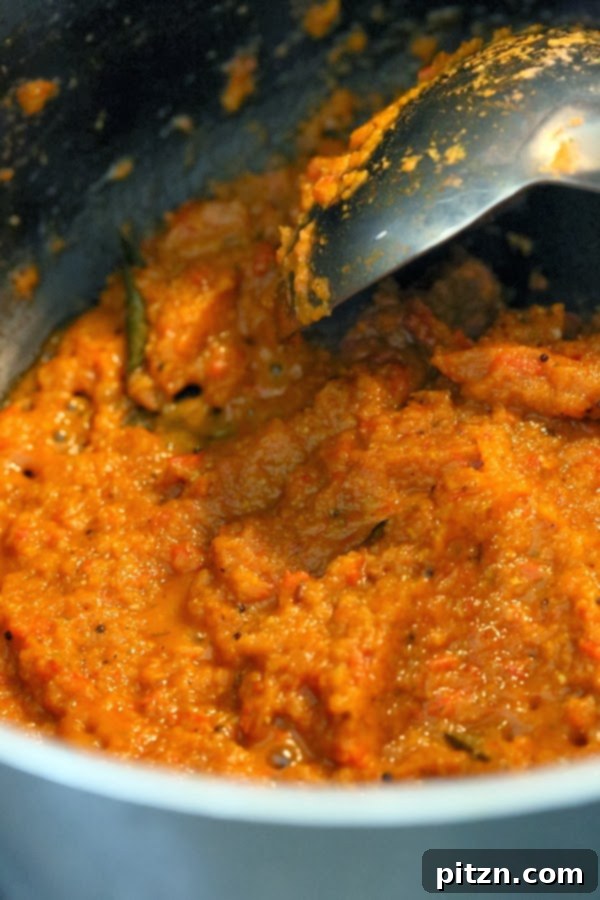 Tomato mixture well-cooked in pan, separating from oil