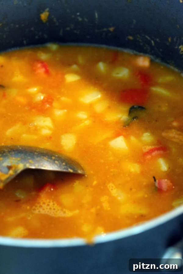 Water being added to potato and tomato mixture for simmering