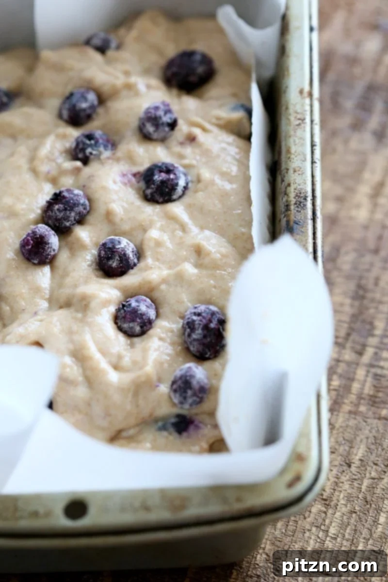 Mixing the fluffy vegan batter with fresh blueberries for a delicious Lemon Blueberry Cake.