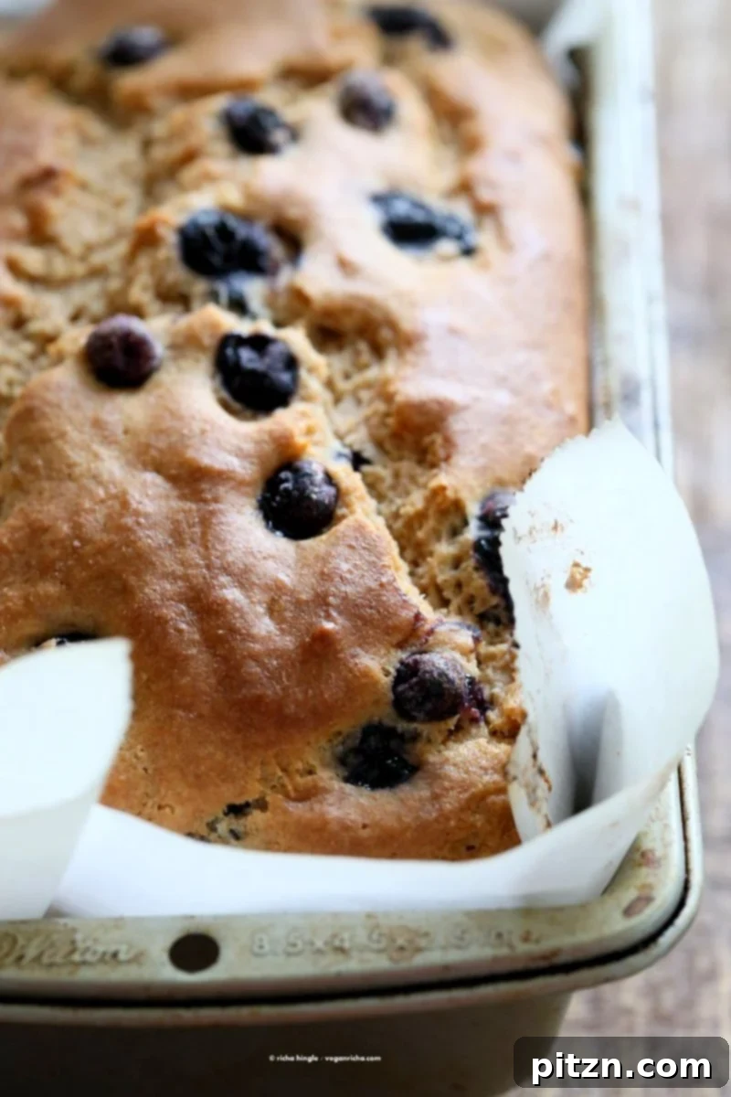 Golden brown Vegan Lemon Blueberry Pound Cake baking in the oven, filling the kitchen with a sweet aroma.