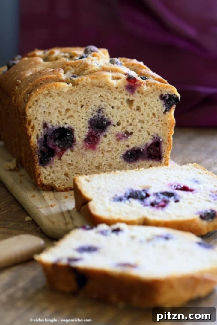 Perfectly sliced Vegan Lemon Blueberry Cake loaf, showcasing its moist texture and juicy blueberries, ready to serve.