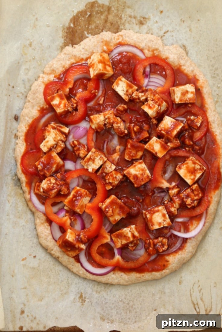 Fiery Vegan Sriracha BBQ Tofu Pizza with Zesty Pepper Jack on Spelt Crust 4 Assembling a Vegan BBQ Tofu Pizza with pepper jack cheese before baking.