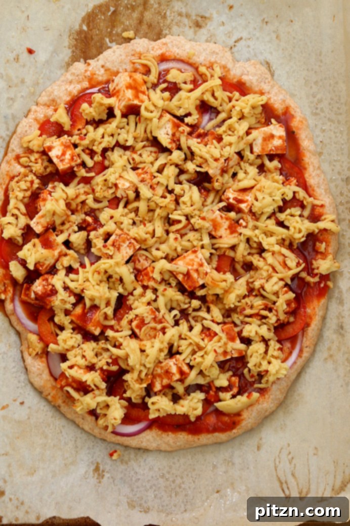 Fiery Vegan Sriracha BBQ Tofu Pizza with Zesty Pepper Jack on Spelt Crust 5 Adding shredded almond milk pepper jack cheese to a Vegan BBQ Tofu Pizza.