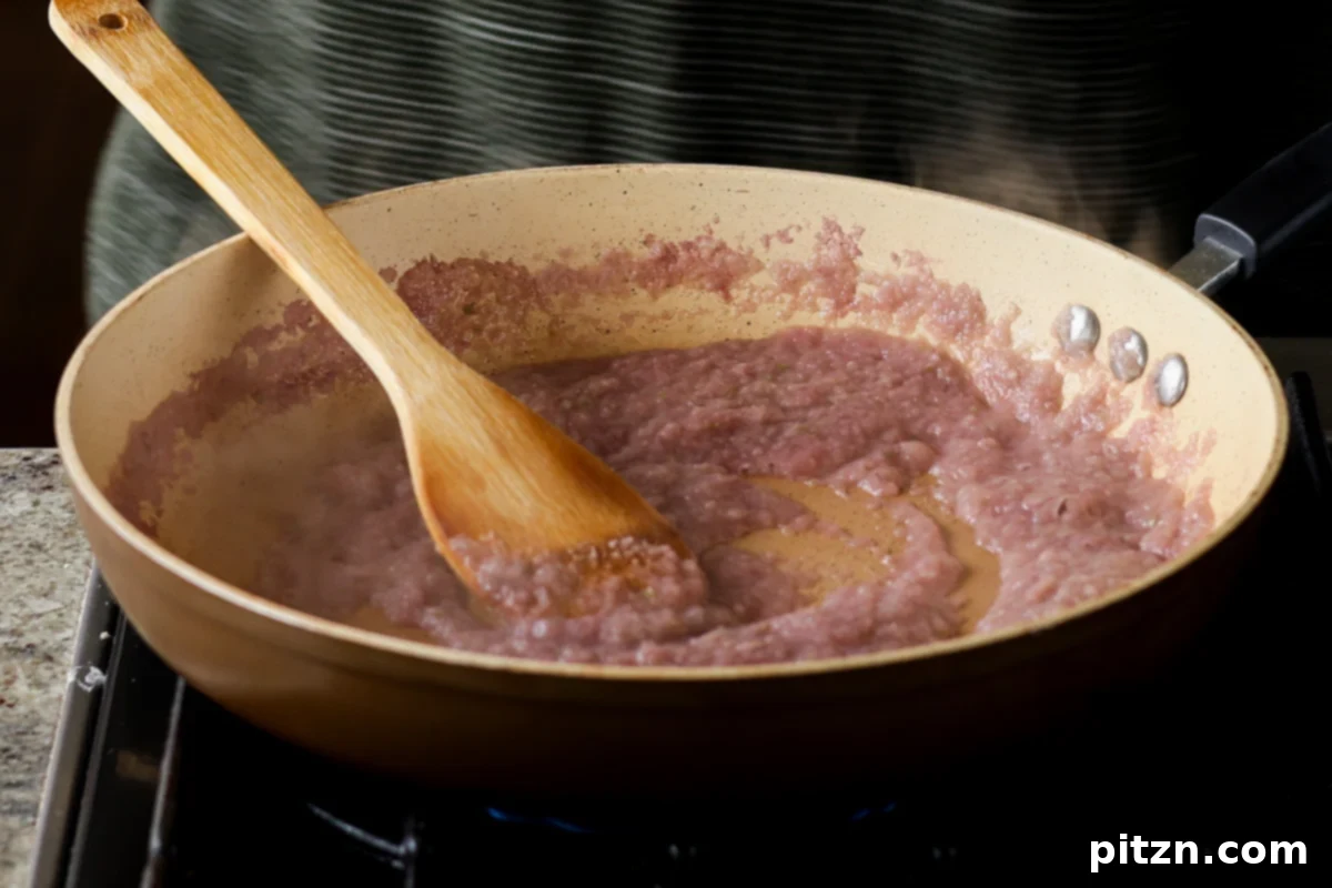 The raw aromatic mixture in a skillet, just added after blending, ready to be sautéed.