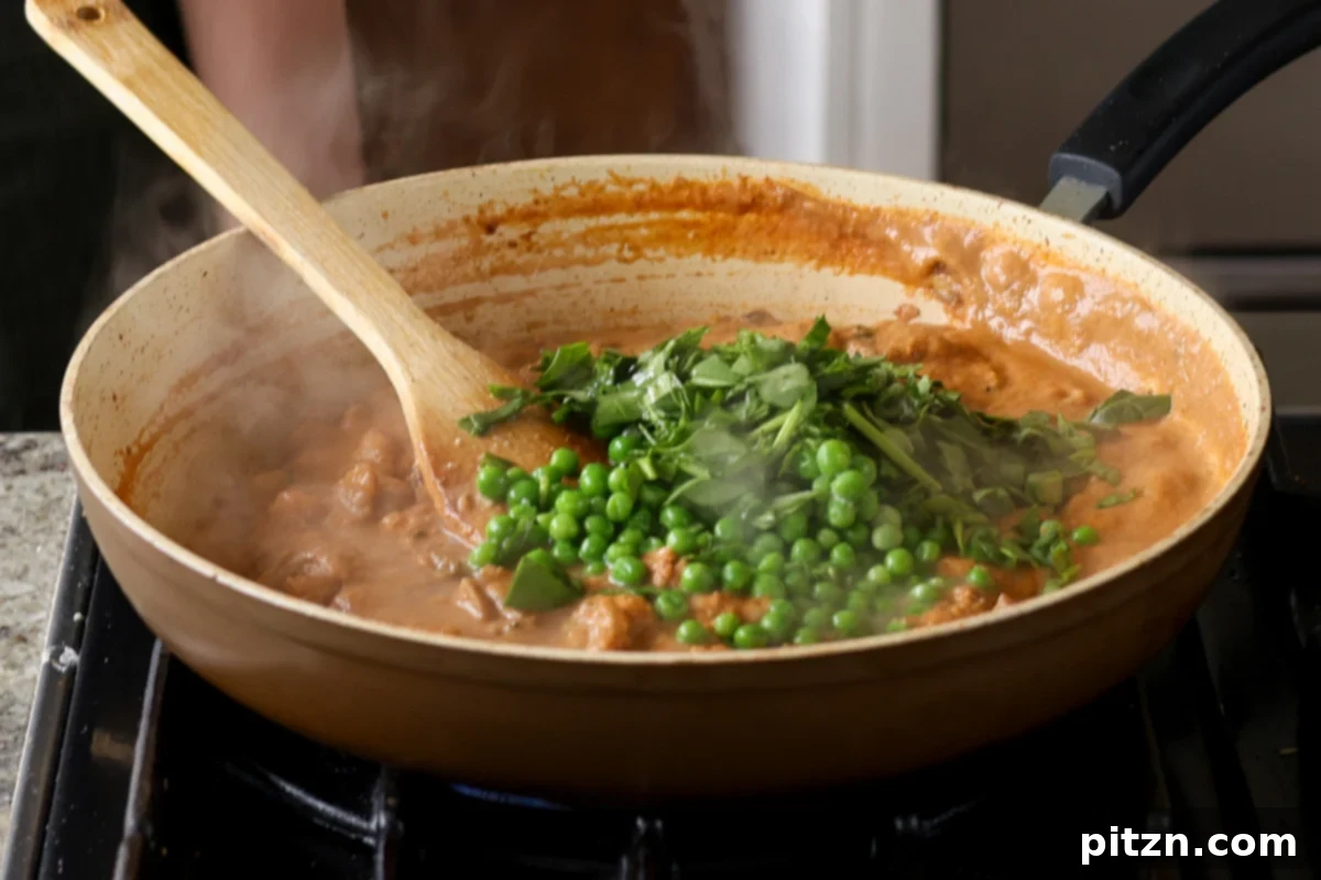 Adding vibrant green peas and fresh spinach to the bubbling matar masala, infusing freshness into the curry.